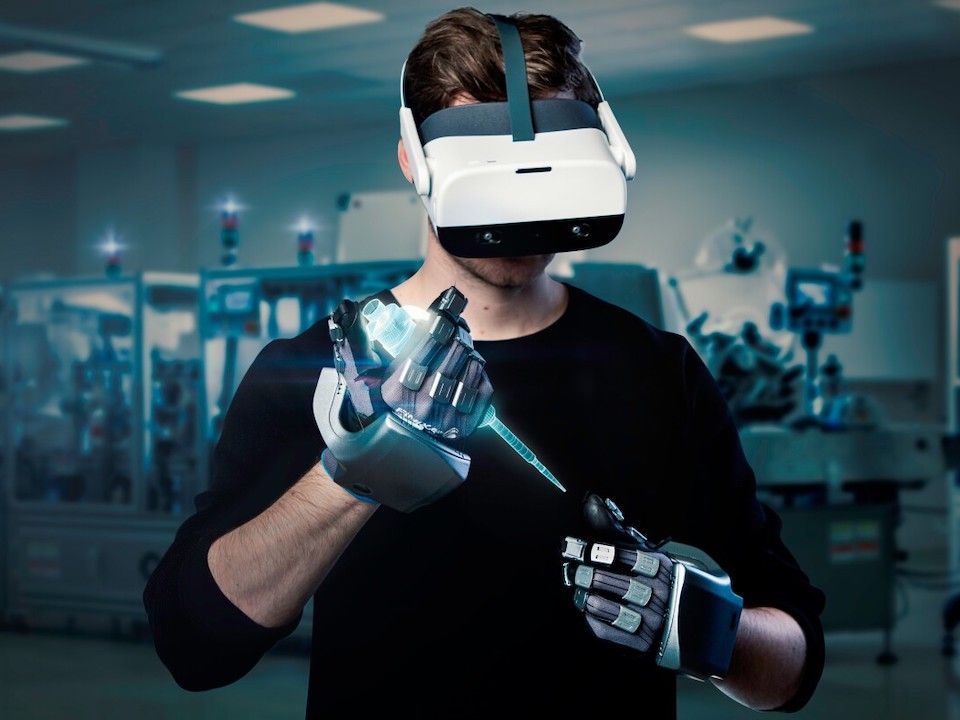 A person wearing a VR headset and haptic gloves.